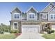 Beautiful townhome featuring a stone facade, 2-car garage and manicured landscaping at 8426 Garnet Rose Ln, Raleigh, NC 27615