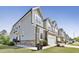 Row of townhouses with stone facade, green siding, two-car garages, and manicured lawns at 8426 Garnet Rose Ln, Raleigh, NC 27615