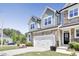 Charming townhouse with a stone facade, green siding, and a two-car garage at 8426 Garnet Rose Ln, Raleigh, NC 27615