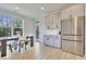 Bright kitchen features gray cabinets, stainless steel refrigerator, and dining area at 8426 Garnet Rose Ln, Raleigh, NC 27615