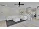Spacious living room featuring a plush white sofa, modern ceiling fan, and sleek hardwood floors at 8426 Garnet Rose Ln, Raleigh, NC 27615