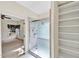 Bright bathroom featuring a glass enclosed shower and open shelving, with a view into an adjoining bedroom at 8629 Swarthmore Dr, Raleigh, NC 27615