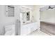 Bright bathroom with white double sink vanity, toilet, and open shelving with an adjoining bedroom at 8629 Swarthmore Dr, Raleigh, NC 27615