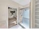 Bright bathroom featuring a glass enclosed shower, with white tiled floor and view to an adjoining bedroom at 8629 Swarthmore Dr, Raleigh, NC 27615