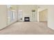 A well-lit living room featuring a fireplace, large windows with shutters, and neutral carpet at 8629 Swarthmore Dr, Raleigh, NC 27615