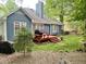 Backyard features deck, spacious lawn, mature trees, and exterior view of home at 8712 Attingham Dr, Raleigh, NC 27615