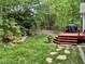 Beautiful backyard featuring a waterfall, landscaped yard, and a spacious deck with a grill at 8712 Attingham Dr, Raleigh, NC 27615