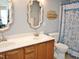 Bathroom with double sinks, wood cabinets, and a decorative mirror at 8712 Attingham Dr, Raleigh, NC 27615