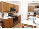 Well-lit kitchen featuring oak cabinets, white countertops, and stainless steel appliances at 8712 Attingham Dr, Raleigh, NC 27615