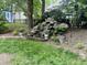 Backyard waterfall with landscaping, lush greenery, and mature trees at 8712 Attingham Dr, Raleigh, NC 27615