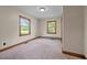 Bright bedroom featuring two large windows, neutral-toned walls, and plush carpeting at 901D Gibson Rd, Mebane, NC 27302