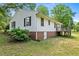 Exterior view of home's back side with brick foundation, lawn, and a wooden deck at 901D Gibson Rd, Mebane, NC 27302