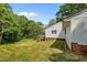 Home's back exterior shows a staircase to a deck on a lush lawn with trees at 901D Gibson Rd, Mebane, NC 27302
