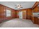 Cozy living room featuring wood-paneled walls, neutral carpet, and a classic ceiling fan with lighting at 901D Gibson Rd, Mebane, NC 27302