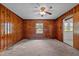 Inviting living room showcasing wood-paneled walls, a large window, and a traditional ceiling fan at 901D Gibson Rd, Mebane, NC 27302