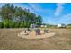 The backyard features a fire pit with chairs and a shed among mature trees at 93 Fallingbrook Dr, Kenly, NC 27542