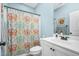 Bathroom featuring a colorful shower curtain, white vanity, and blue walls creating a vibrant and fresh space at 93 Fallingbrook Dr, Kenly, NC 27542