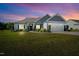 Inviting single-story home with a well-kept lawn and attached two-car garage under a beautiful sunset at 93 Fallingbrook Dr, Kenly, NC 27542