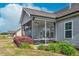 Inviting screened porch with outdoor seating, offering views of the landscaped backyard and a peaceful retreat at 93 Fallingbrook Dr, Kenly, NC 27542