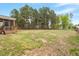 Expansive backyard featuring a screened porch, lush greenery, and a natural wood fence at 101 Jewell Farm Lane, Holly Springs, NC 27540
