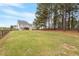 Spacious backyard with a combination of grassy areas and wooded area with firepit offers versatility and privacy at 101 Jewell Farm Lane, Holly Springs, NC 27540
