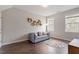 A bonus room features a loveseat, windows, and an accent wall with decorative wooden hexagons at 101 Jewell Farm Lane, Holly Springs, NC 27540