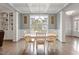 Elegant dining area featuring coffered ceilings, a modern chandelier, and hardwood floors, ideal for formal entertaining at 101 Jewell Farm Lane, Holly Springs, NC 27540