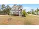 Two-story home features stone and gray siding, covered porch, manicured lawn, and professional landscaping at 101 Jewell Farm Lane, Holly Springs, NC 27540