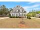 Charming two-story home with stone and gray siding, professional landscaping, and a well-manicured front yard at 101 Jewell Farm Lane, Holly Springs, NC 27540