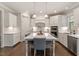 Bright kitchen featuring white cabinets, stainless appliances, large island with seating and views of the cooktop at 101 Jewell Farm Lane, Holly Springs, NC 27540