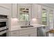 Close-up showcasing modern kitchen design with stainless steel sink, white quartz countertops, and subway tile backsplash at 101 Jewell Farm Lane, Holly Springs, NC 27540