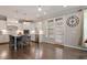 Open-concept kitchen featuring white cabinets, stainless appliances, and a dining area with access to the deck at 101 Jewell Farm Lane, Holly Springs, NC 27540