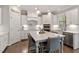 Well-lit kitchen with modern white cabinets, stainless steel appliances, and a large island with seating at 101 Jewell Farm Lane, Holly Springs, NC 27540