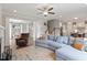Inviting living room featuring a large sectional sofa, ceiling fan, and access to the kitchen and dining areas at 101 Jewell Farm Lane, Holly Springs, NC 27540