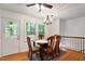 Dining area featuring a chandelier, hardwood floors, and natural light, perfect for Gathering gatherings at 104 Argyle Ct, Garner, NC 27529