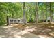 Home nestled among trees with a driveway and front yard, showcasing a serene setting at 104 Argyle Ct, Garner, NC 27529