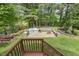 Spacious backyard featuring a built-in grill, an outdoor stone fireplace, and a picnic table under string lights at 104 Caley Rd, Apex, NC 27502