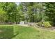 Manicured backyard with a built-in grill, outdoor fireplace, and a classic tiered fountain surrounded by lush landscaping at 104 Caley Rd, Apex, NC 27502