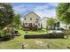 Well-maintained backyard with a built-in grill, a patio, a deck, manicured landscaping, and an expansive lawn at 104 Caley Rd, Apex, NC 27502