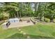 Open backyard featuring a built-in grilling station and a fire pit with stone benches surrounded by lush green lawn at 104 Caley Rd, Apex, NC 27502