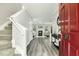 Inviting foyer with grey wood floors, stairs, neutral walls, and a view into the living room at 104 Caley Rd, Apex, NC 27502