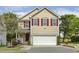 Charming two-story home with a well-manicured lawn, inviting entrance, and red shutters at 104 Caley Rd, Apex, NC 27502
