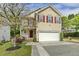 Charming two-story home with a well-manicured lawn, inviting entrance, and red shutters at 104 Caley Rd, Apex, NC 27502