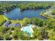 Aerial view of sparkling blue community pool surrounded by mature trees with lake and trees beyond at 105 Breakers Pl, Cary, NC 27511