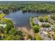 Aerial view of community homes along a pretty lake surrounded by mature trees and lush landscaping at 105 Breakers Pl, Cary, NC 27511