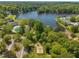 An aerial view shows the community pool, playground, and lake surrounded by lush trees and landscaping at 105 Breakers Pl, Cary, NC 27511