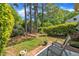 Backyard with patio featuring outdoor seating surrounded by lush greenery and trees at 105 Breakers Pl, Cary, NC 27511