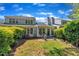 A backyard with a small brick patio is overlooked by the home's many windows and surrounded by trimmed hedges at 105 Breakers Pl, Cary, NC 27511