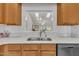 Bright kitchen with stainless steel sink, natural wood cabinets, and view into the living room at 105 Breakers Pl, Cary, NC 27511