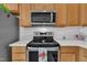Kitchen featuring stainless steel appliances, natural wood cabinets, and white backsplash at 105 Breakers Pl, Cary, NC 27511